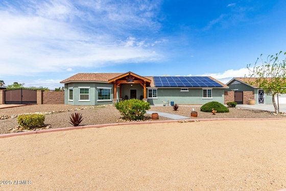 A single-story acre home with a desert yard