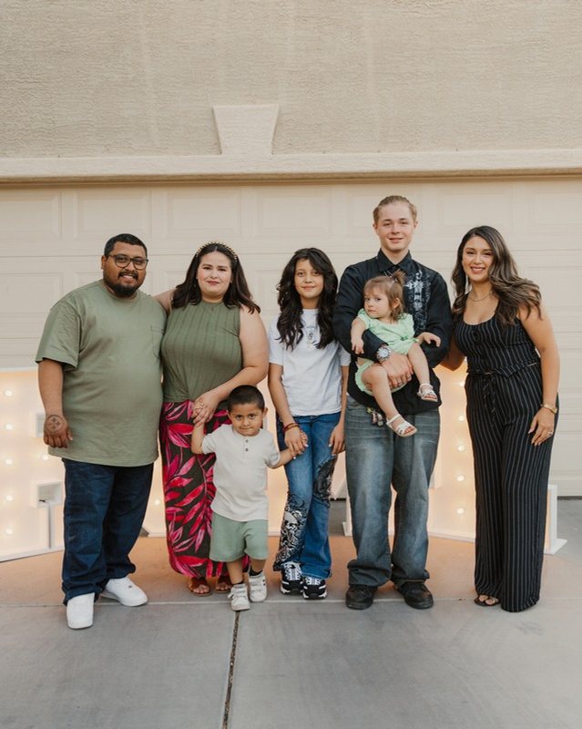 A family celebrating closing day in front of their new home