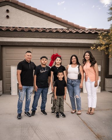 A family in front of their new home's garage